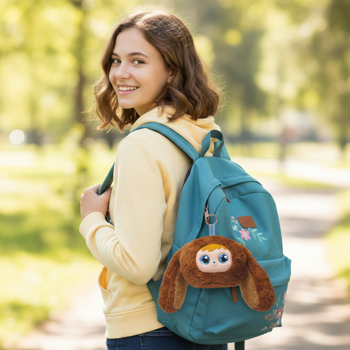 The product is a Lexibook backpack in turquoise color, designed for teenagers. A small plush toy, resembling a cute character, is attached to the front. This backpack targets a young audience, ideal for school or leisure. It features multiple compartments for practical storage and an ergonomic design for comfort. The plush toy adds a playful and appealing touch.